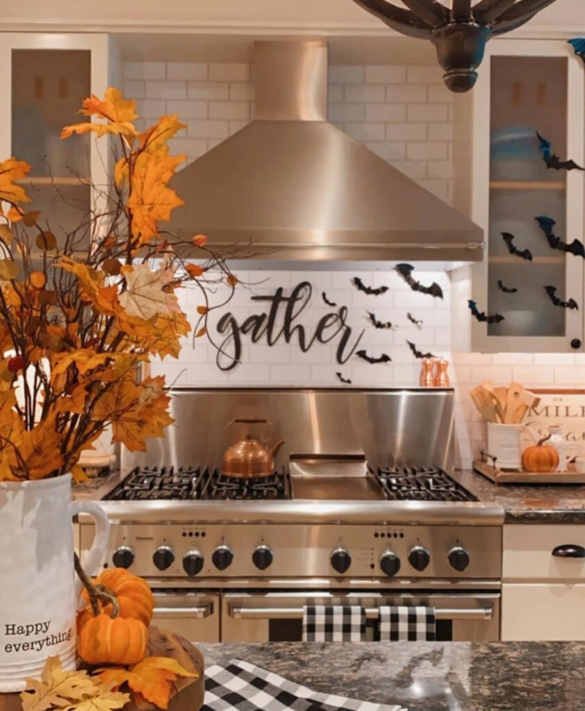 Paper bats arranged across the kitchen backsplash with warm fall stems in a countertop vase.
