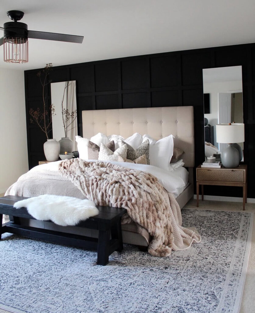 Modern master with black grid feature wall, tufted bed, chunky faux-fur throw, mirrors and black bench — aesthetic fall bedroom decor.