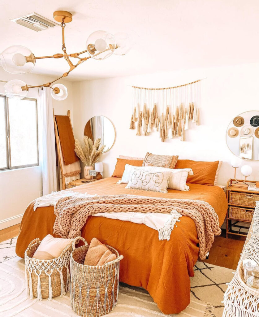 Boho rust linen duvet, chunky knit throw, macramé wall hanging, baskets and pampas — boho fall bedroom ideas.
