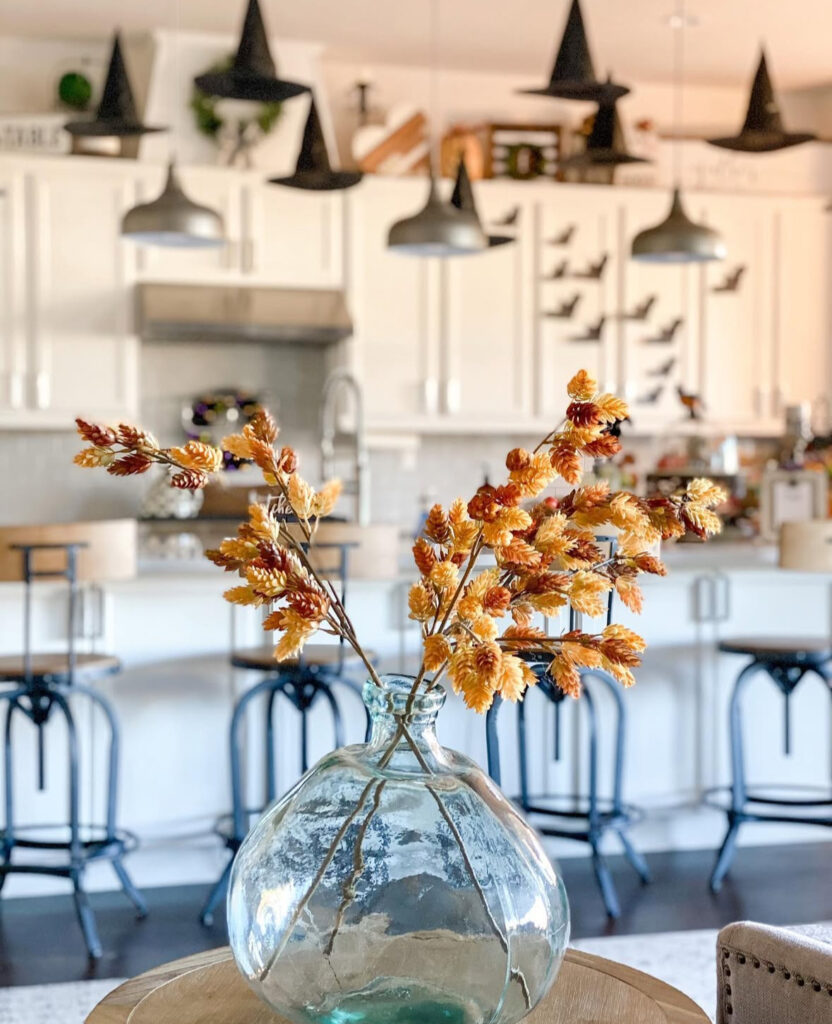 Floating witch hats above the island with a simple vase of autumn branches for color.