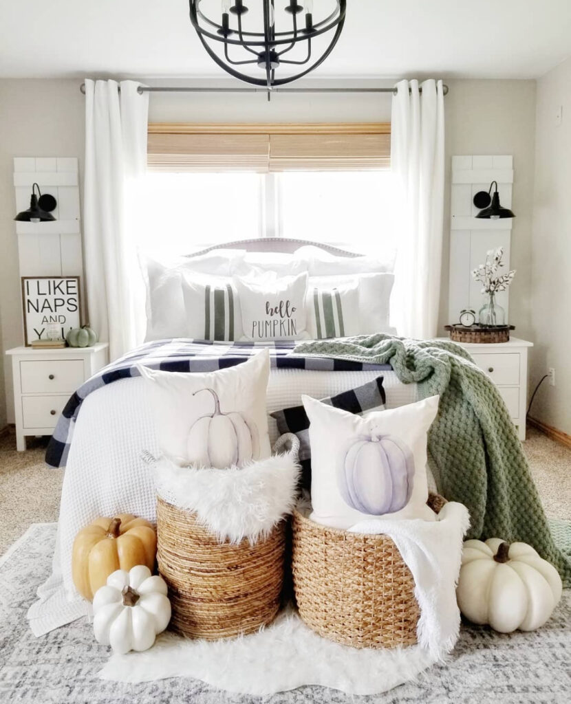 Farmhouse room with buffalo check bedding, green knit throw, woven baskets and white curtains — fall decor bedroom ideas.