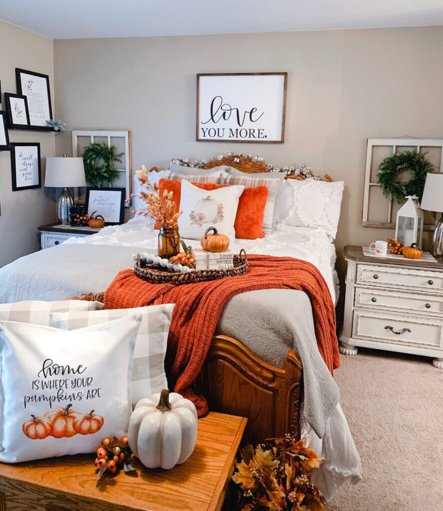 Layered pillows, rust knit throw and pumpkin tray under “Love You More” sign — fall bedroom decorating ideas.