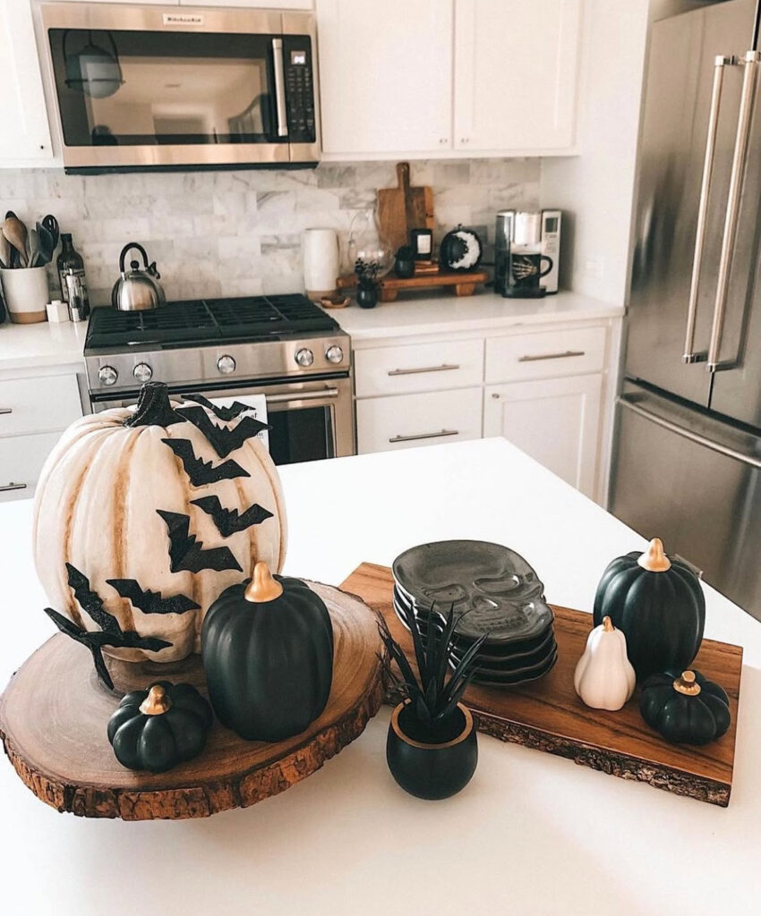 Neutral pumpkins on wood slices creating a simple, modern centerpiece on the kitchen island.