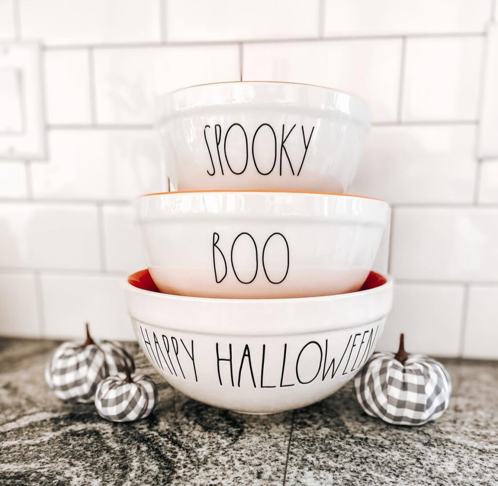 Stacked seasonal mixing bowls flanked by gingham pumpkins for a quick Halloween counter display.