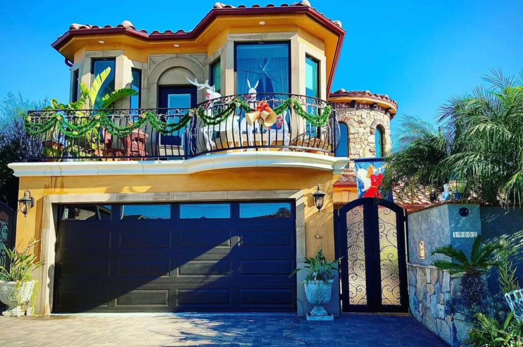Mediterranean balcony with swagged garland, bells, and sleek reindeer silhouettes.