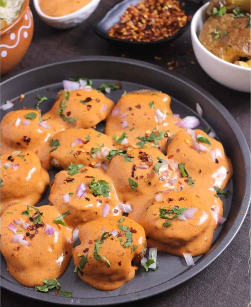 Round fried potatoes smothered in creamy orange Cajun sauce, sprinkled with onions, cilantro, and chile flakes.