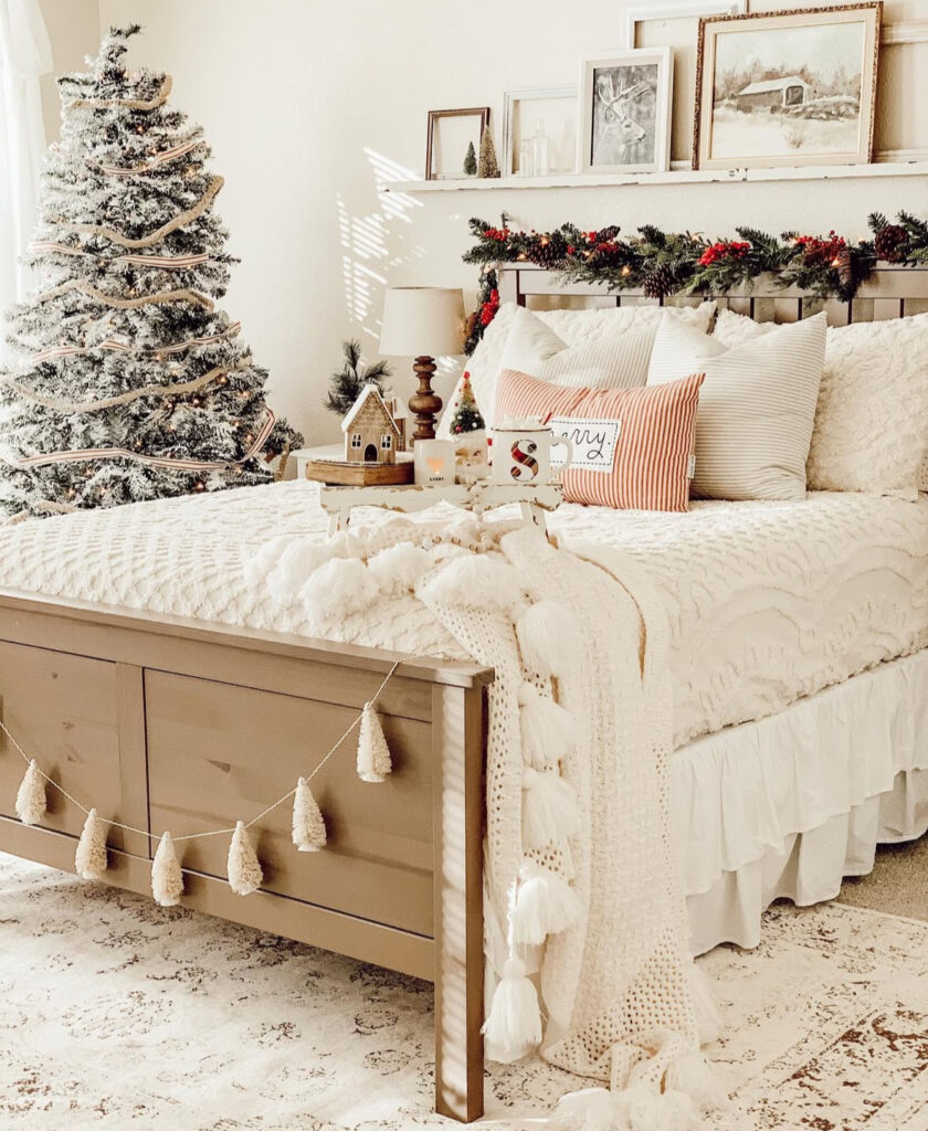Creamy whites, tassel garland, and flocked tree—neutral cozy Christmas bedroom ideas that feel like winter whites. Layered textures make the space warm.