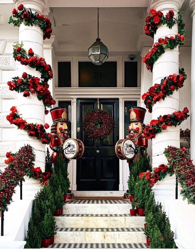 Grand entry with nutcracker soldiers, red berry garlands on columns, and topiaries.