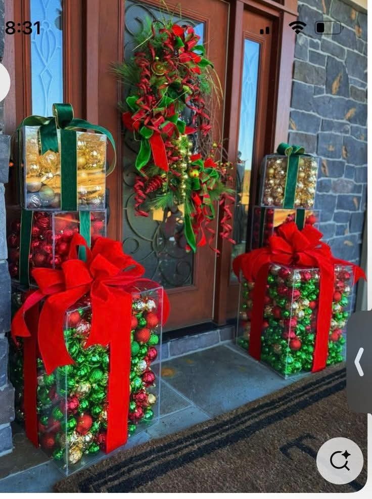 Front door flanked by clear gift boxes filled with ornaments and velvet bows.