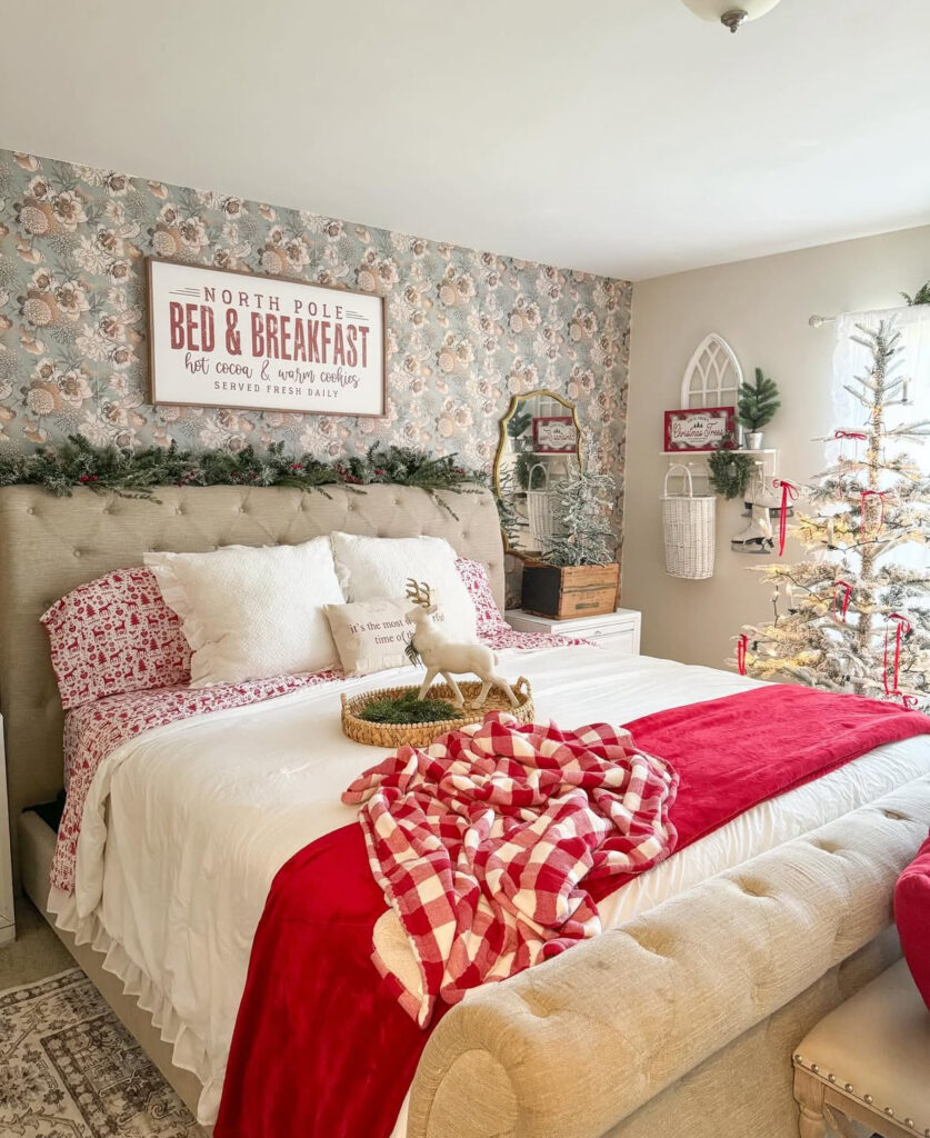 Floral wallpaper with garland and reindeer tray—whimsical Christmas decoration ideas for bedroom. Red-and-white linens bring the holiday palette home.