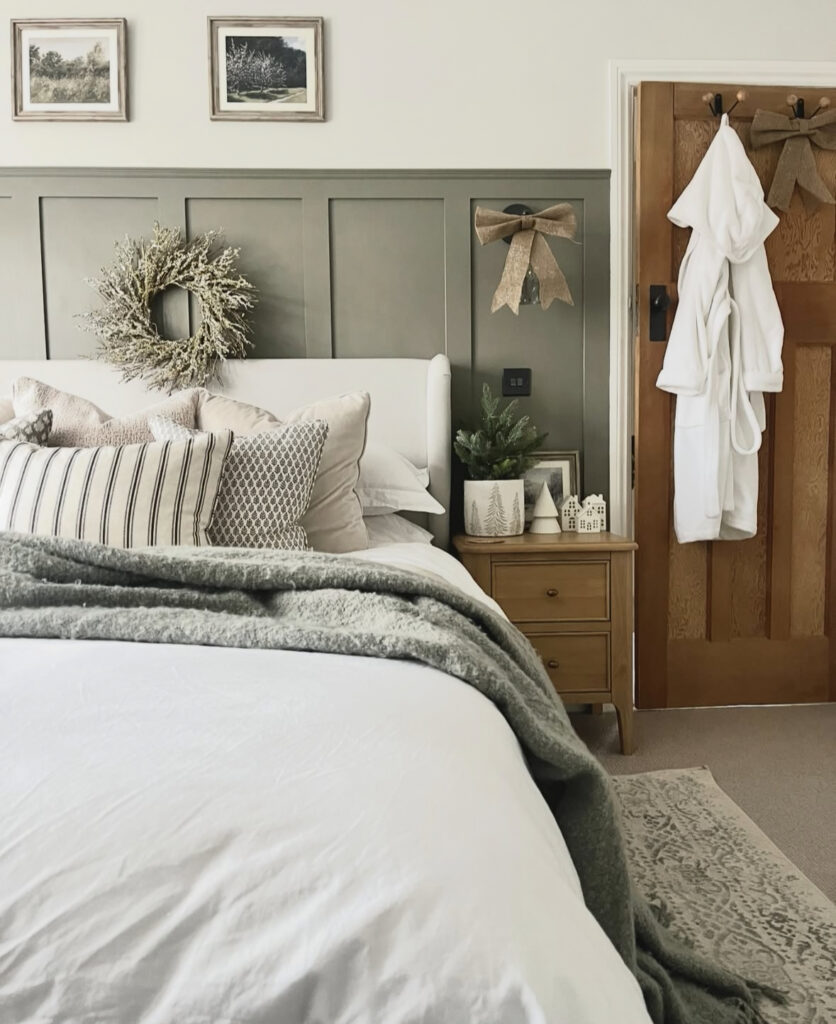 Olive board-and-batten wall with wreath and burlap bows—elegant Christmas decoration ideas for bedroom in farmhouse style. Minimal greenery keeps it calm.
