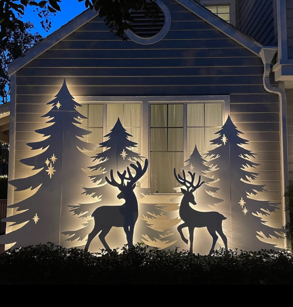 Backlit wall art of reindeer and pine trees creating dramatic shadow silhouettes.