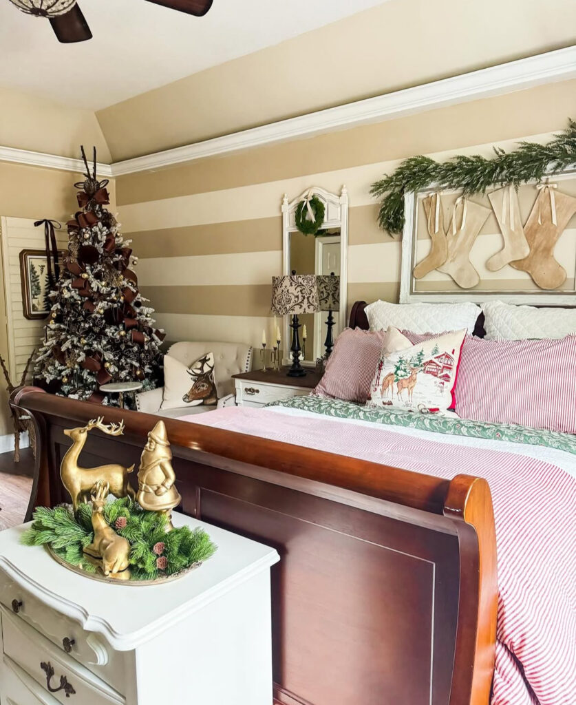 Sleigh bed with striped linens and garland-framed stockings—vintage cozy Christmas bedroom ideas. Brown-ribboned tree matches warm wood tones.