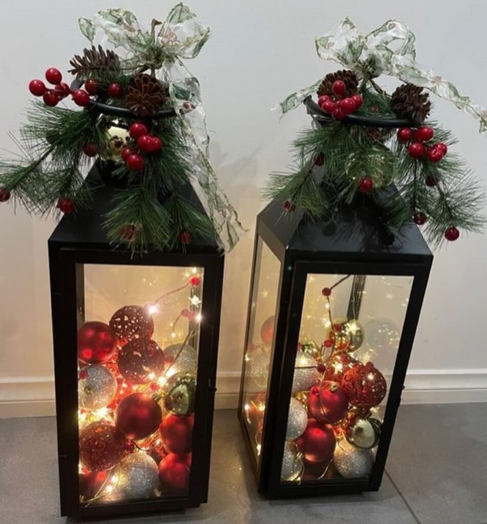 Lantern filled with red berries, baubles, and bright holiday accents