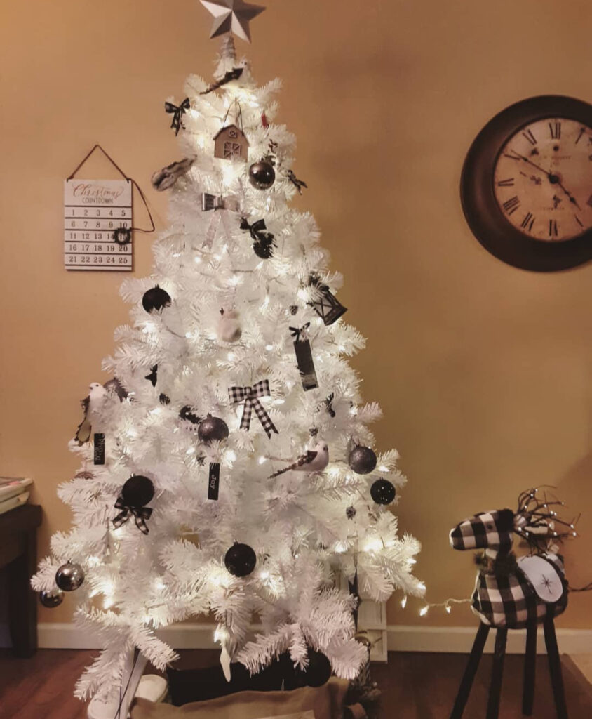 Monochrome bows and buffalo check show how to decorate a white christmas tree in black-and-white style.