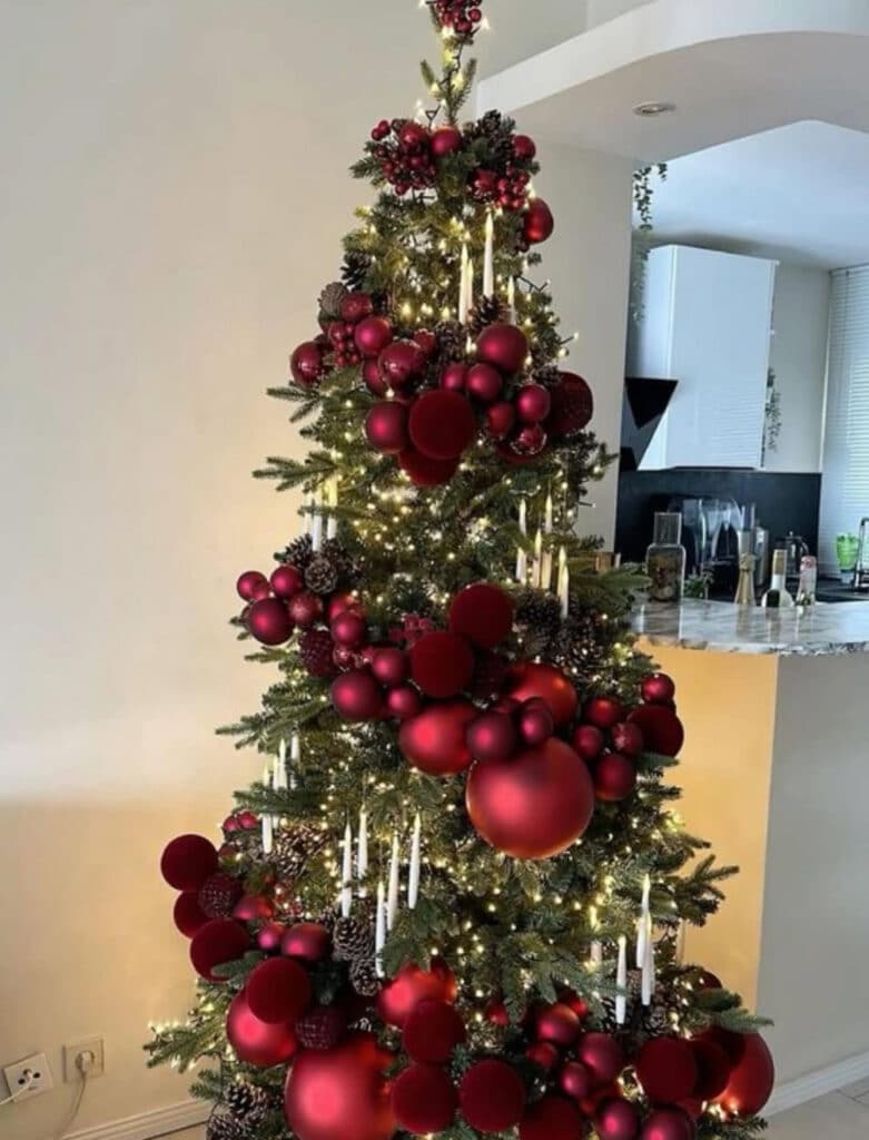 Candlelit burgundy Christmas tree with cascading cranberry ribbons
