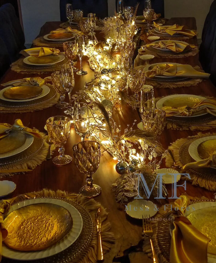 Candlelit gold garland down wood table with crystal glassware.