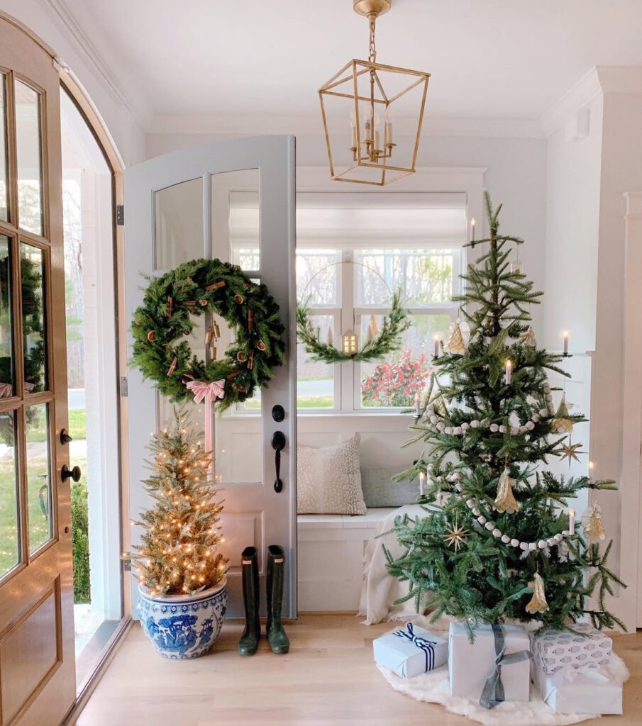 Candlelit Christmas tree creating a warm entryway glow