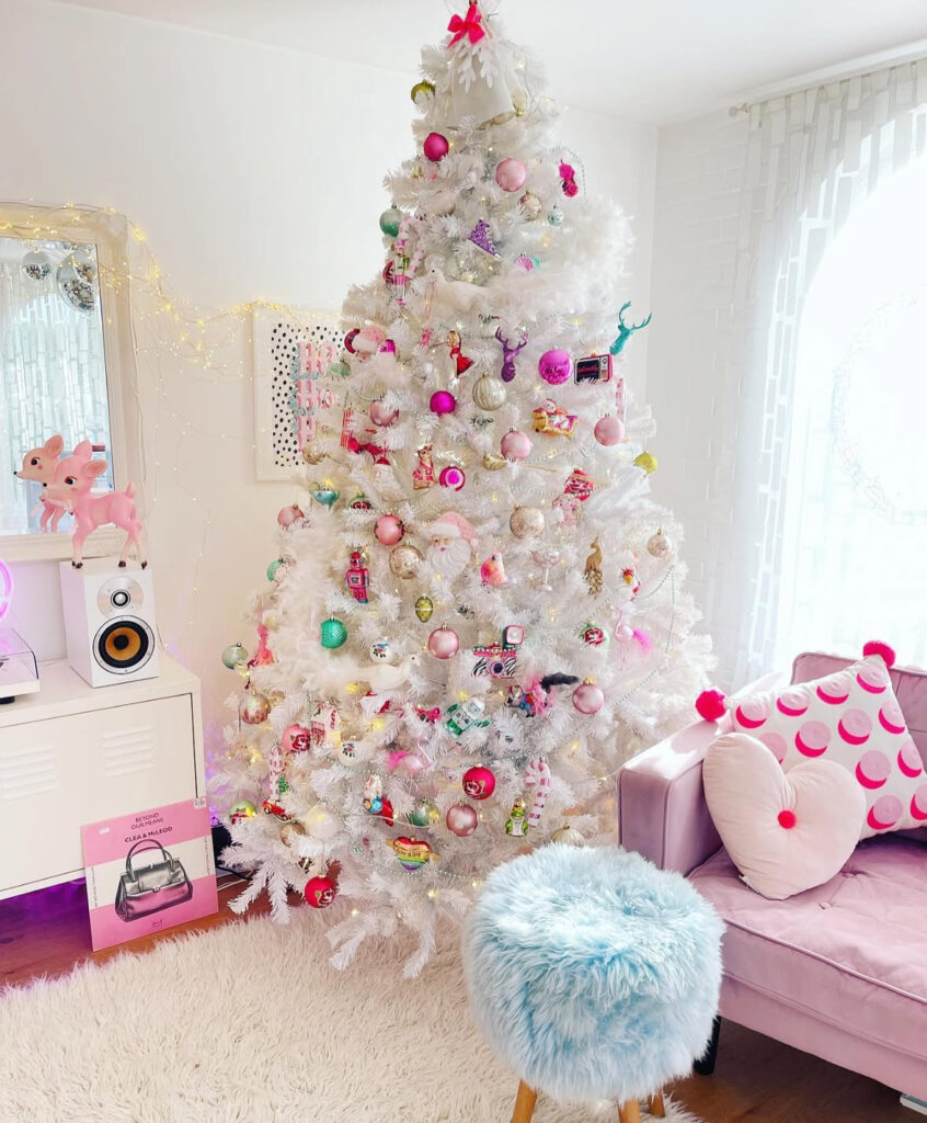 Candy-shop look—playful white christmas tree with colored lights and pop-pink ornaments.