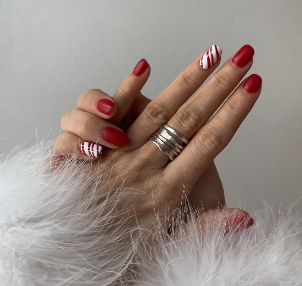 Cranberry matte nails with two candy cane accent designs