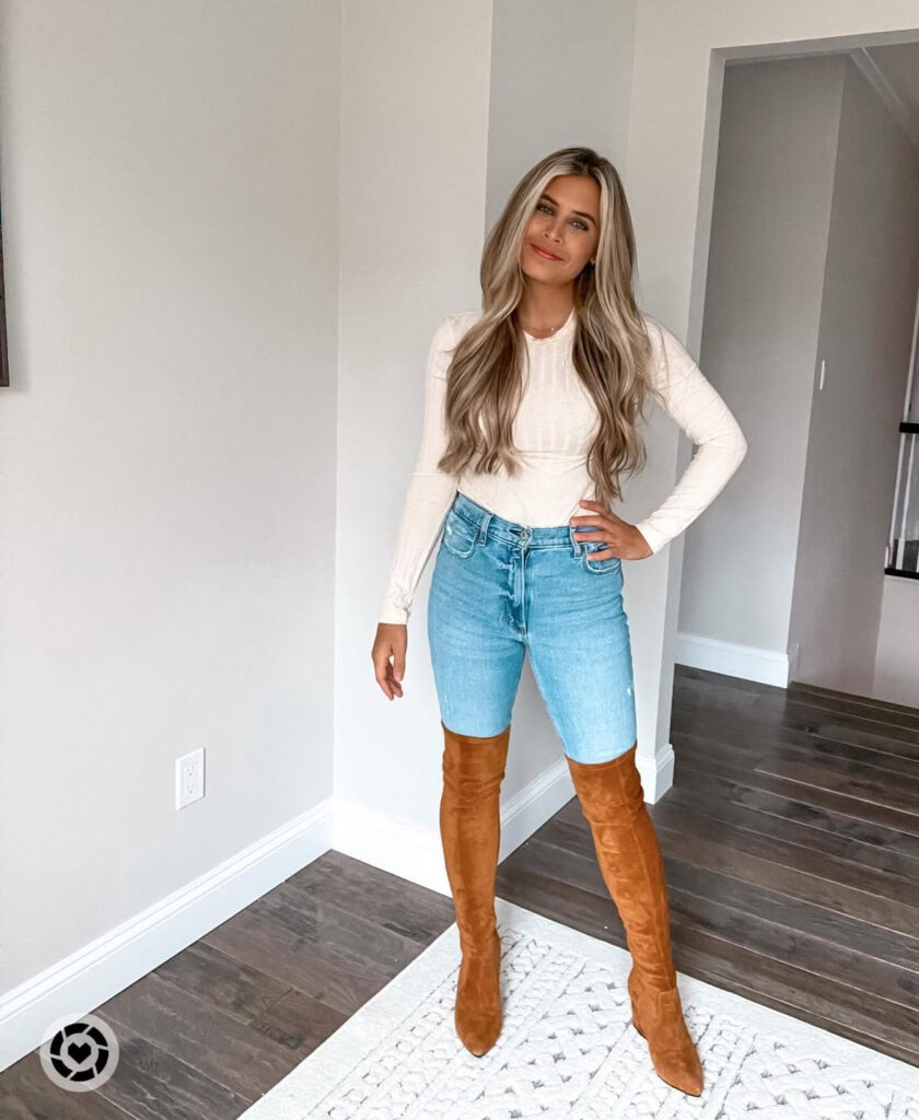 Mirror selfie of a neutral Fair-Isle cardigan with light wide-leg jeans and moccasin flats in a cozy wood-trimmed room.