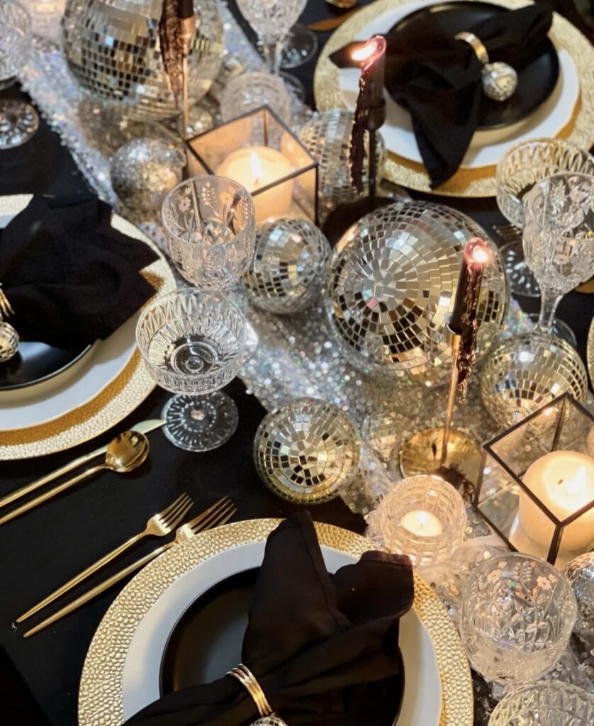 Sequined runner lined with disco balls, candles, and gold chargers.