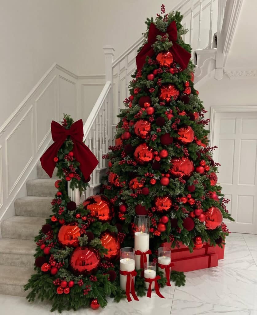 Burgundy Christmas tree beside stairs with layered ribbon decor