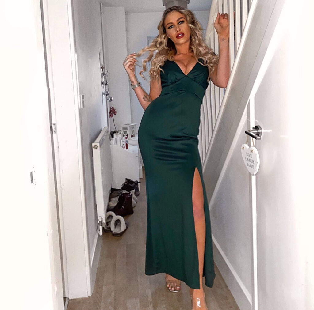 Emerald satin slip dress with thigh slit and clear heels; minimalist new years eve outfits look.