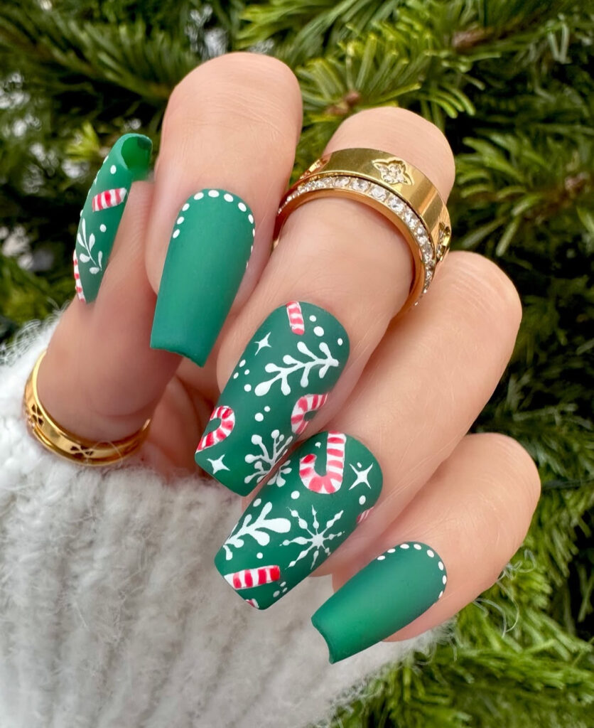 Matte evergreen candy cane nails with painted mints, snowflakes, and dots.