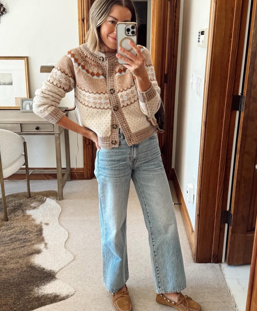 Cropped view of chunky striped sweater in rust and beige with light jeans, tan platform Chelsea boots, and a small brown bag.