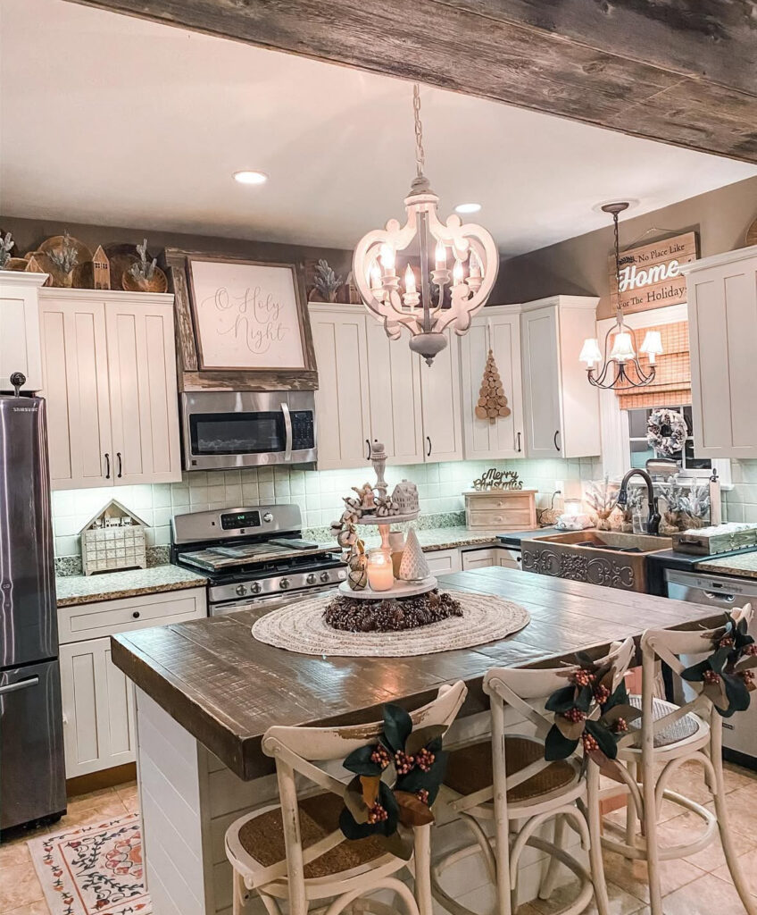 Farmhouse island with braided mat and tiered tray of candles, greenery, and ornaments; magnolia chair decor.