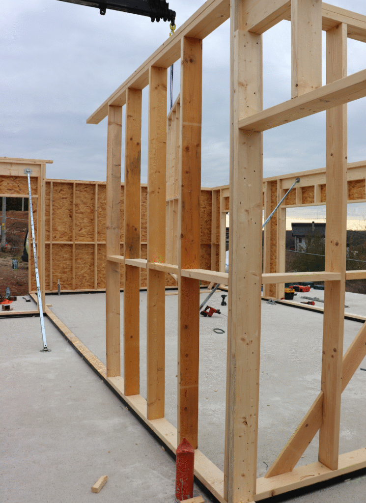 Close-up of first floor framing: 15 cm vertical studs, window opening and temporary bracing.