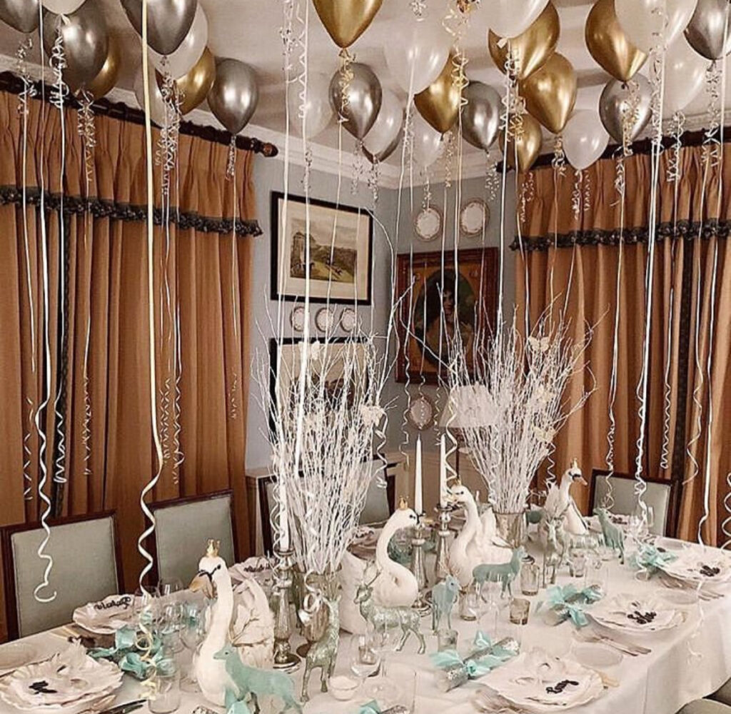 Winter swan centerpiece with white branches and ceiling balloons.