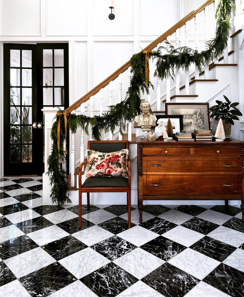 Grand entrance hallway decorated with an old world Christmas tree and garland
