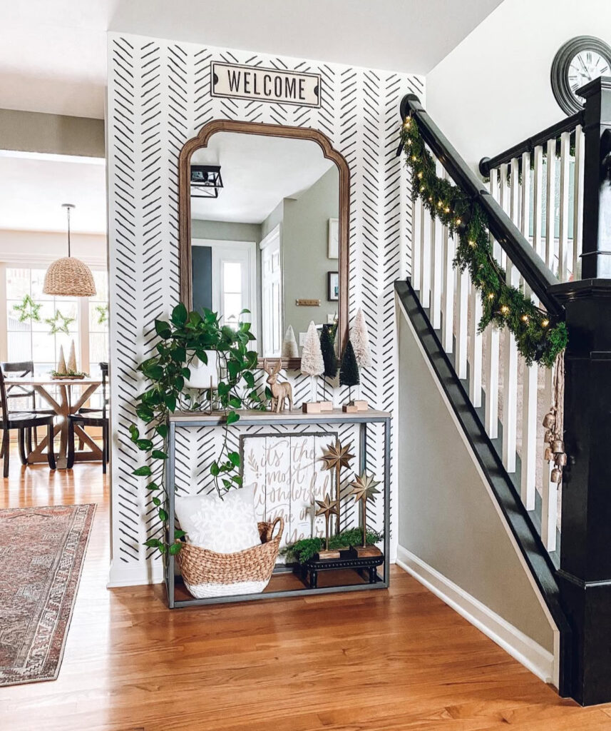 Entryway with graphic wall art and soft green Christmas garland