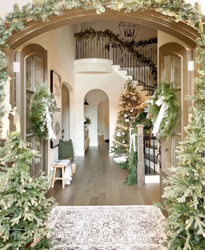 Entryway filled with lush greenery creating a festive first impression