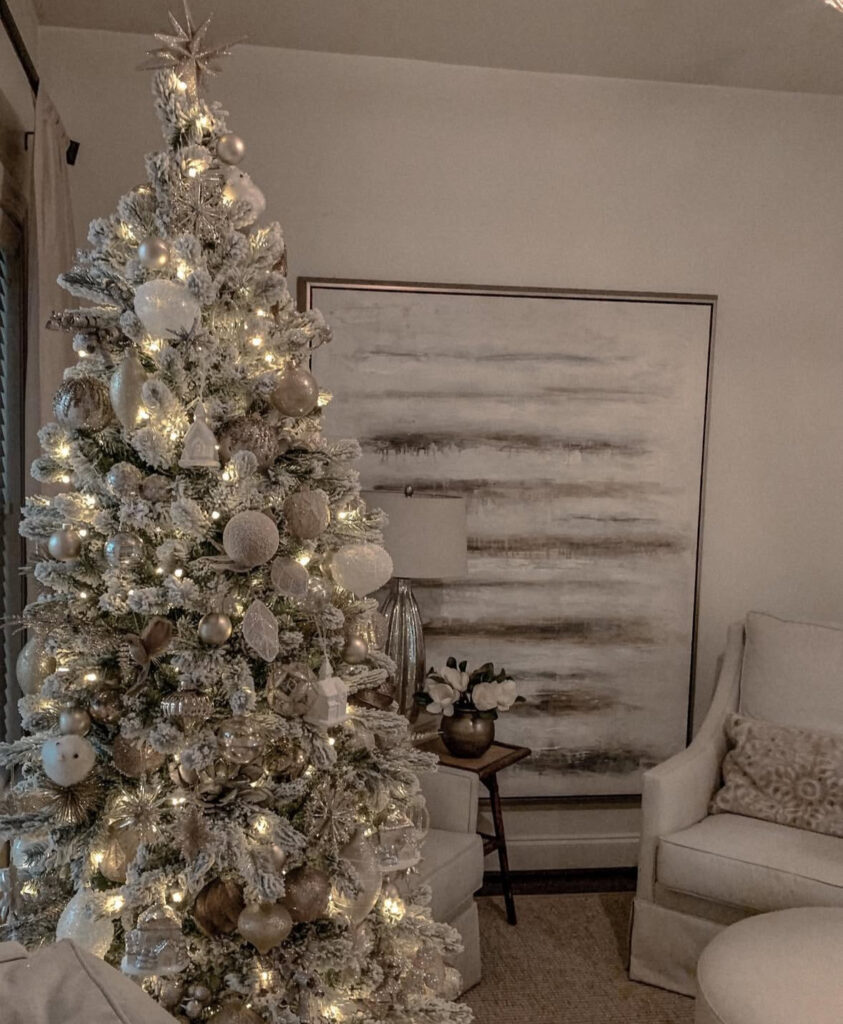 Flocked champagne palette—cozy white and gold christmas tree in a neutral living room.