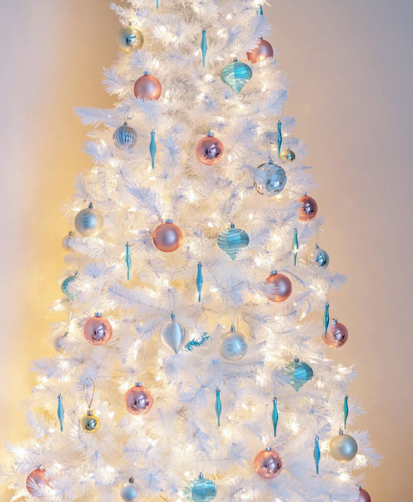 Icy citrus palette—white and blue christmas tree with teal drops and peach baubles.