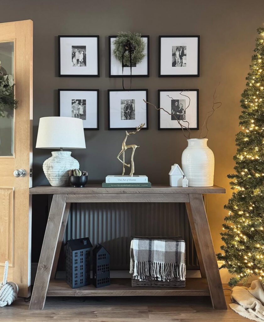 Modern console table decorated with moody tones and family grid wall