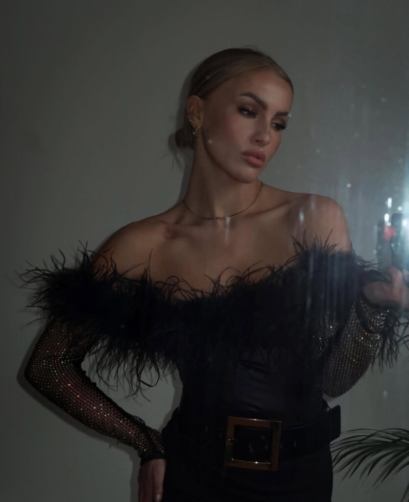 Off-shoulder feather band dress with rhinestone mesh sleeves and wide belt; standout women&#039;s new years eve outfits.