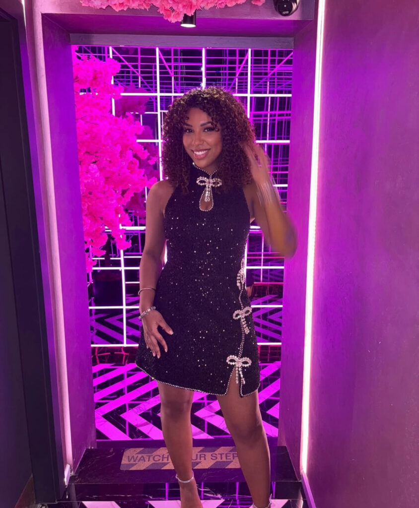 Halter micro-glitter LBD with pearl-trim bows and asymmetric slit; sleek new years eve outfits.