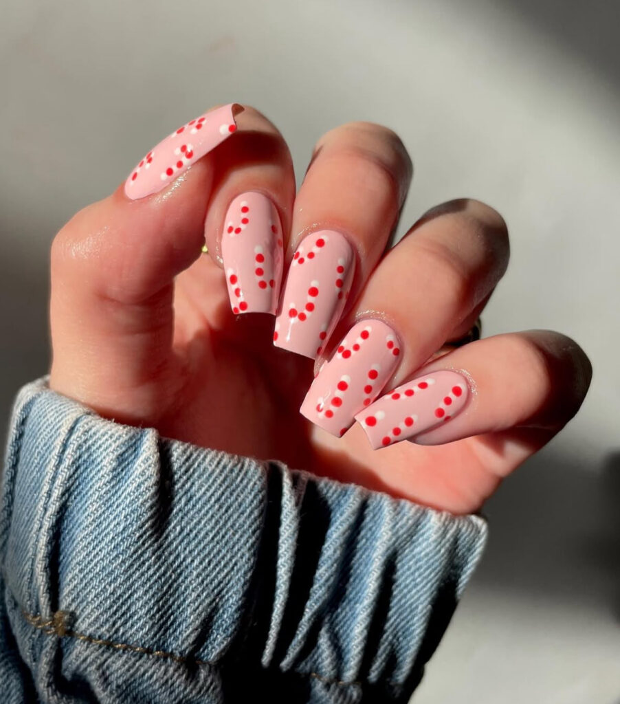 Polka dot peppermint nail design with white confetti details