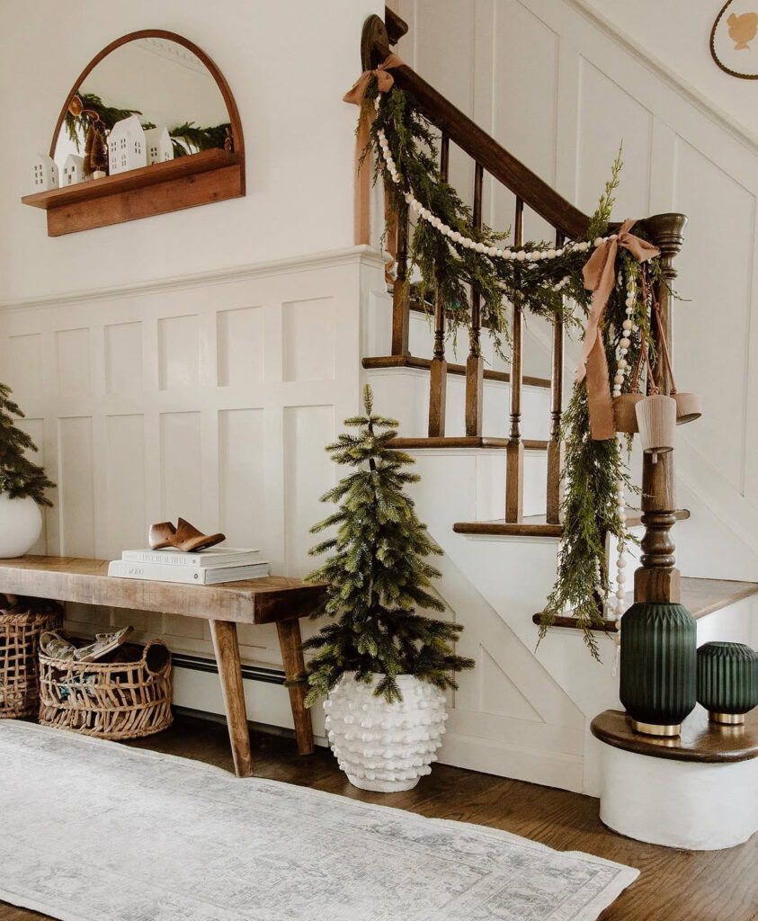 Pom pom garland and bell tied banister decorated for Christmas