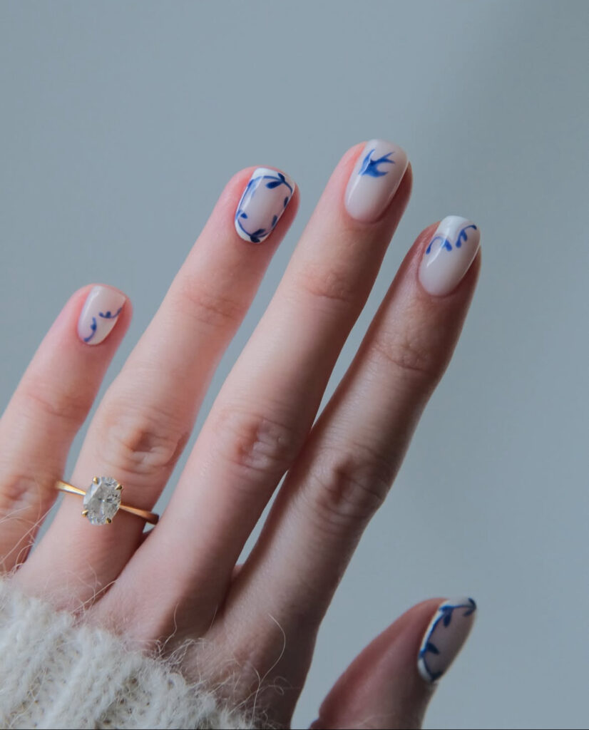Porcelain white nails with fine blue vine accents