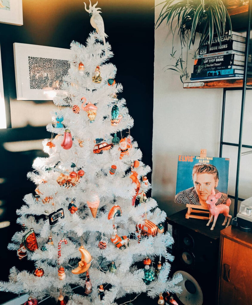 Retro party white christmas tree with colored lights vibe, packed with playful ornaments.