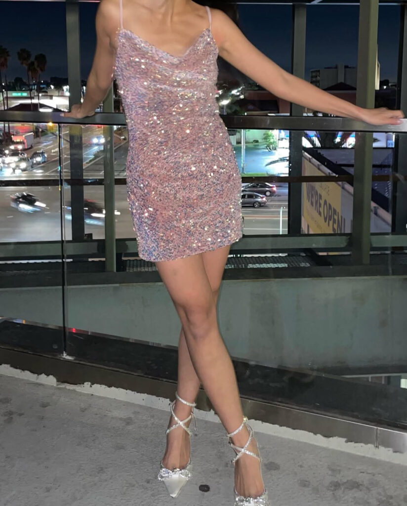 Blush glitter slip dress with lace-up heels on city balcony; romantic sexy new years eve outfits.
