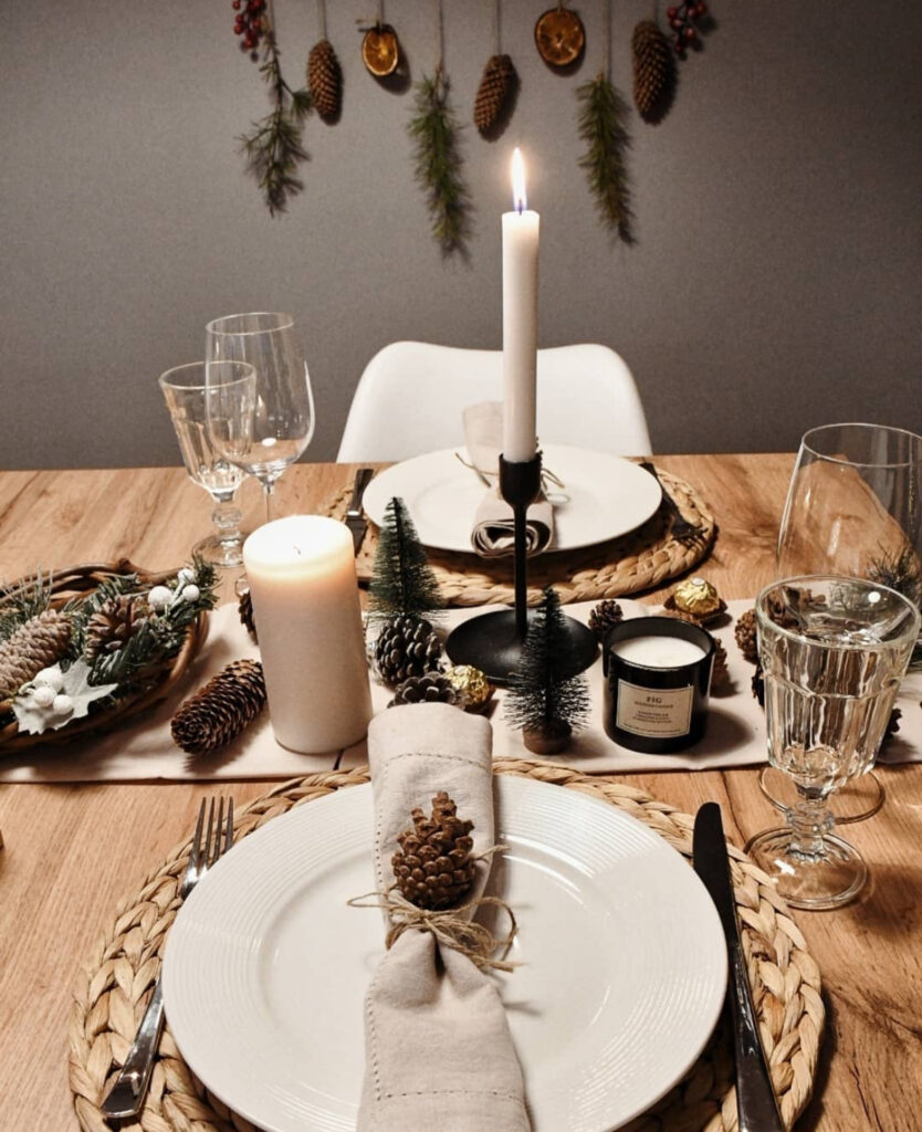 Rustic Nordic table with pinecones, linen napkins, and woven placemats.