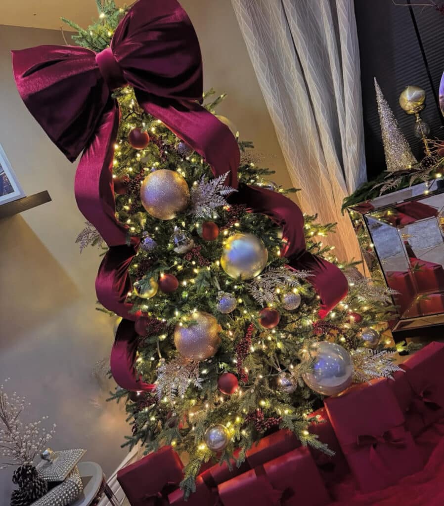 Large velvet bow on a dramatic burgundy Christmas tree