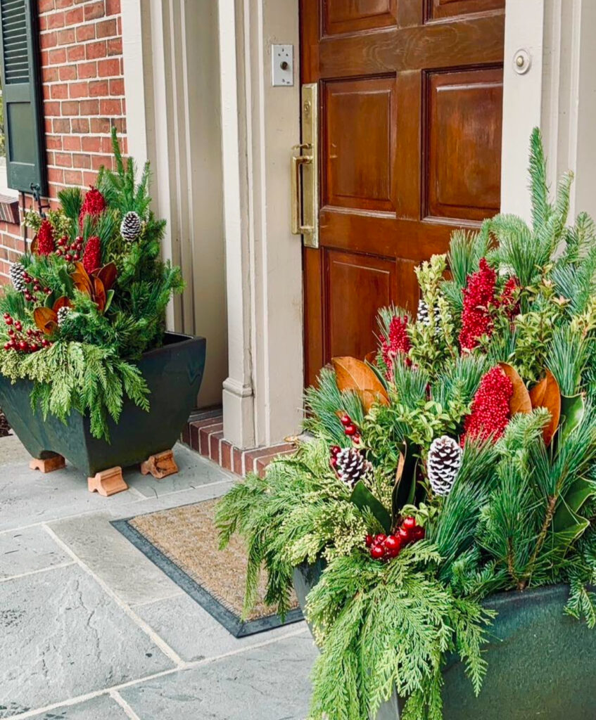 Matching planters with pine, cedar, berries, and frosted cones—balanced outdoor Christmas planter ideas for a polished threshold.