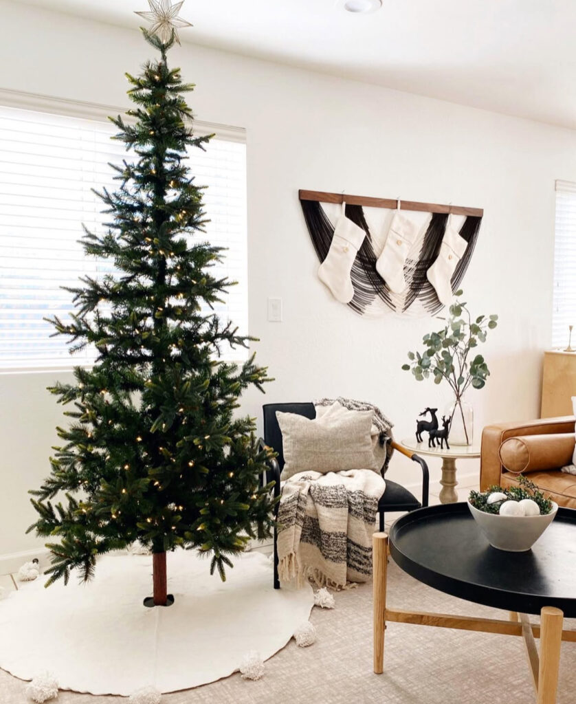 minimal bohemian Christmas corner with stockings on a wall rack